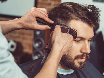 the-hands-of-young-barber-making-haircut-to-attractive-man-in-barbershop.jpg